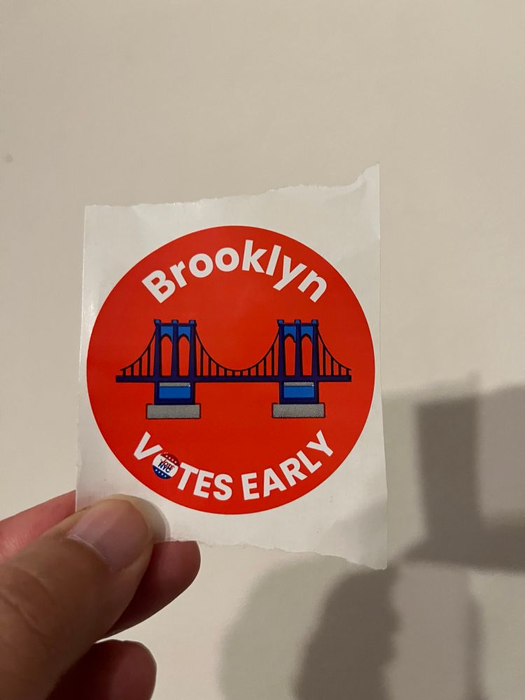 A red circular voting sticker showing the Brooklyn Bridge with the words ‘Brooklyn Votes Early’ in text 