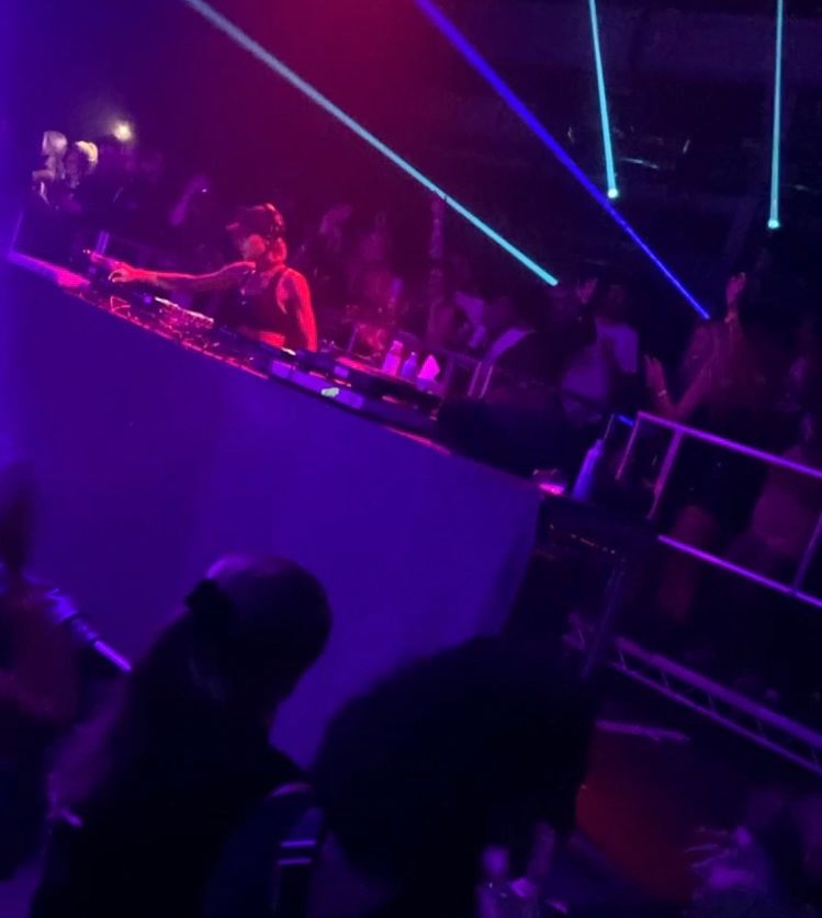 Honey Dijon djing in Bristol at the weekend. Honey is reaching an arm over the decks with lights and lazers and people dancing