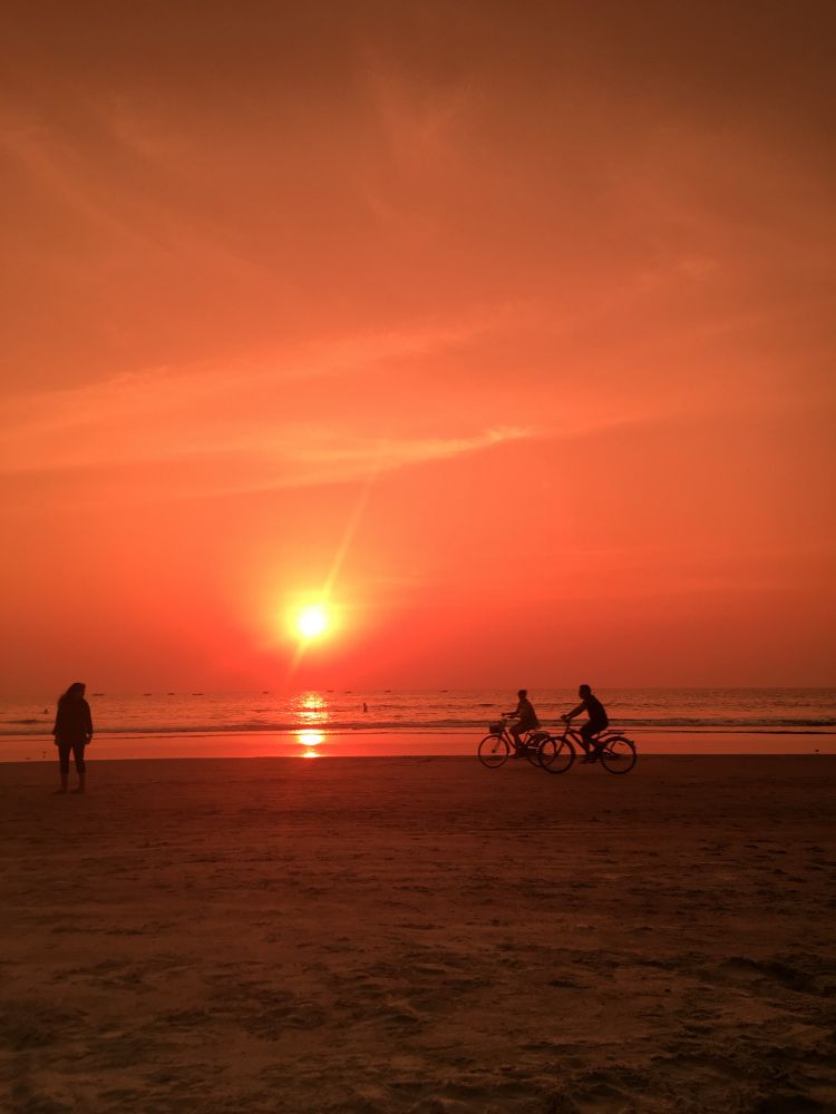 Two people on bikes by a sunset