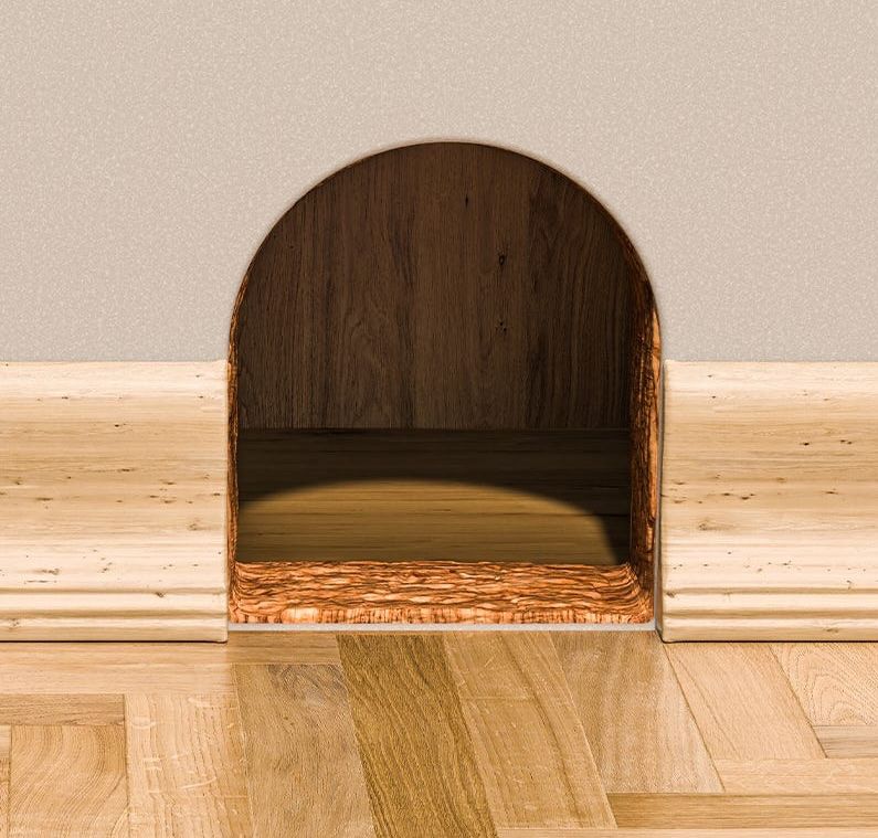 A small, neatly cut hole in the bottom of a wall, with a half-circle curve at the top. There is a thin cork flooring at the entrance to the hole, and the room inside has a finished wall and flooring. 