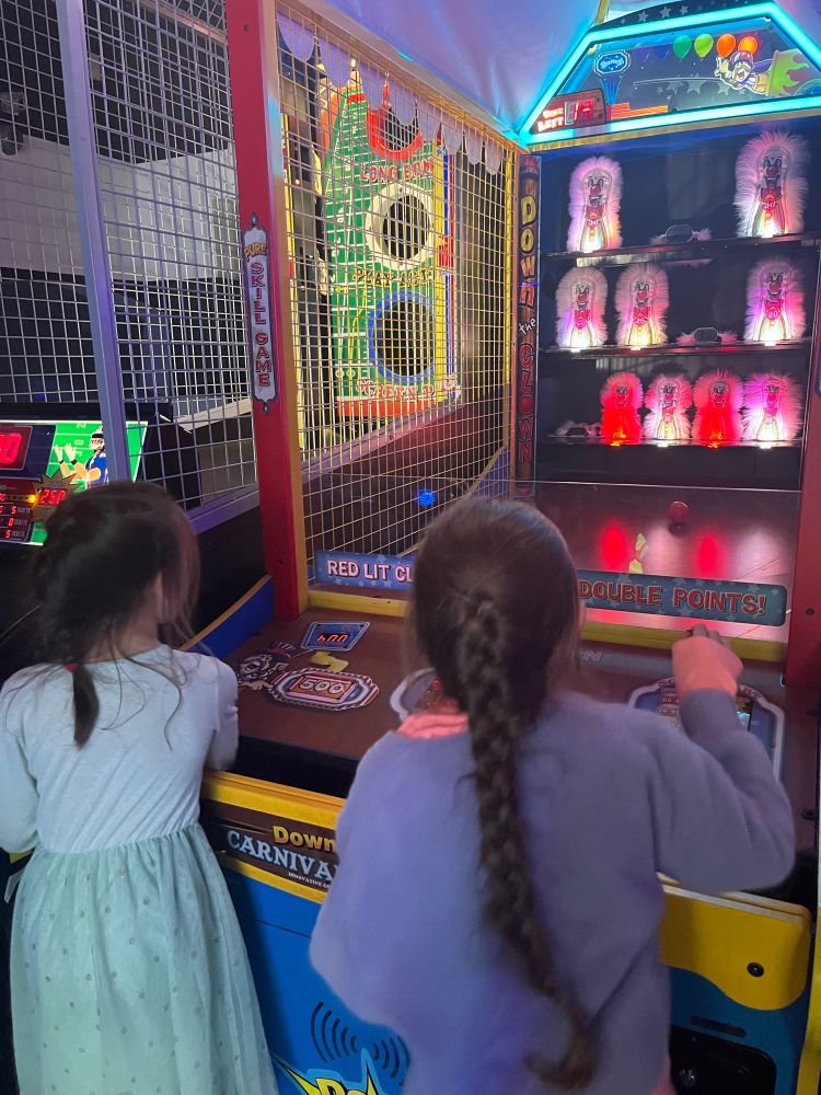 Two kids looking at a spooky clown arcade game