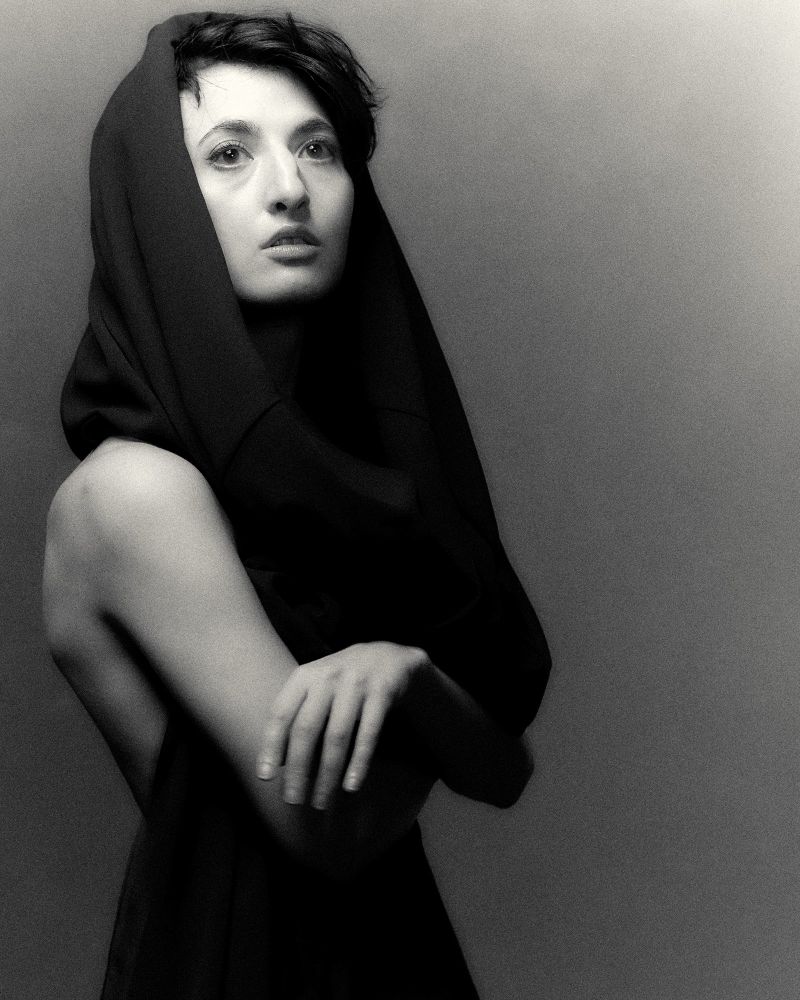 Black and white portrait of a woman with a shawl draped over her