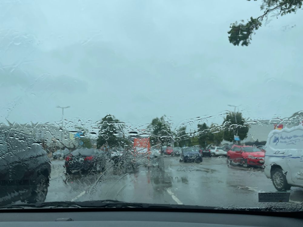 View through rainy windscreen of grey B&Q carpark