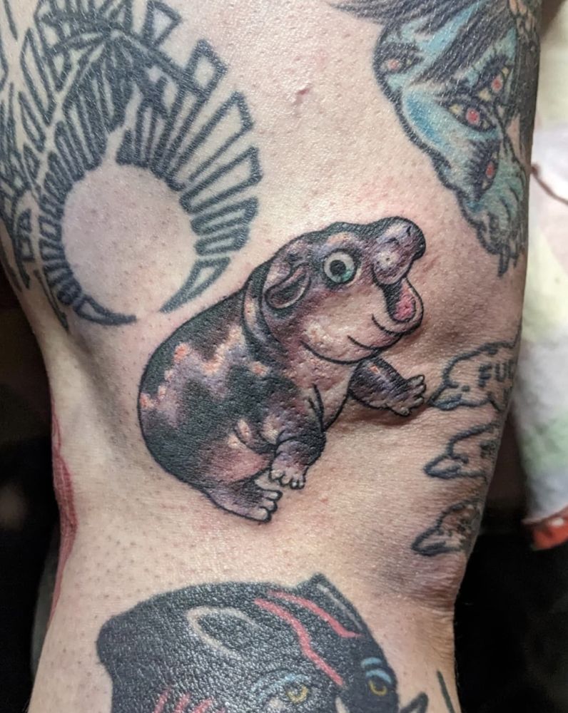 tattoo of the hippo moo deng on the side knee