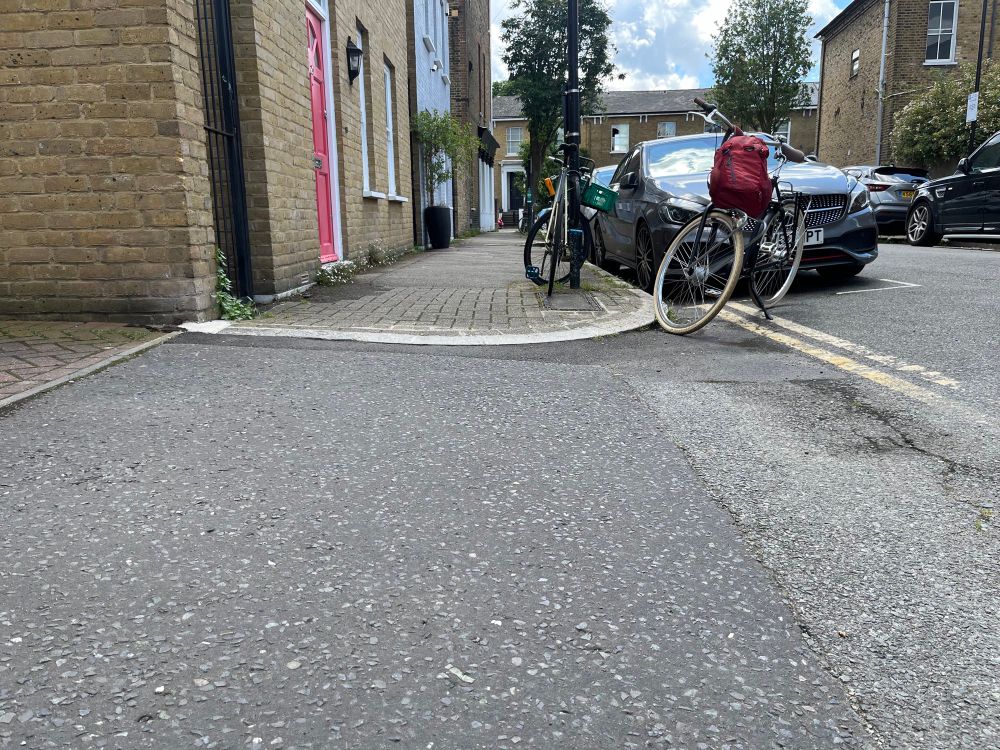 On the far side of an entrance way, the dropped kerb, for access to the pavement, has now been made flush with the road surface