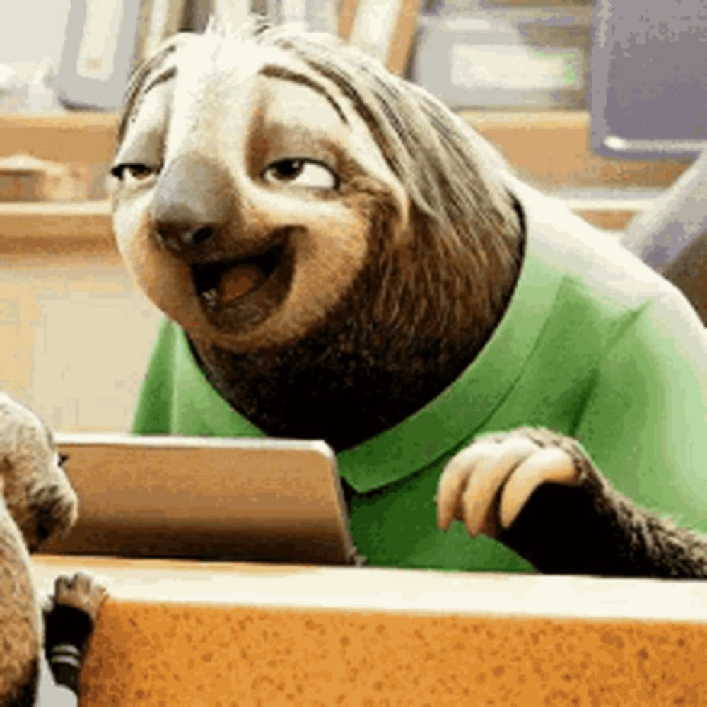 a cartoon sloth wearing a green shirt is sitting at a table .