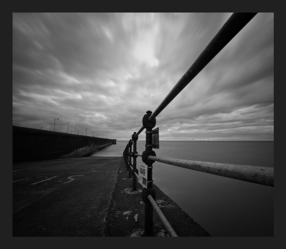 Leading lines into the sea in black and white