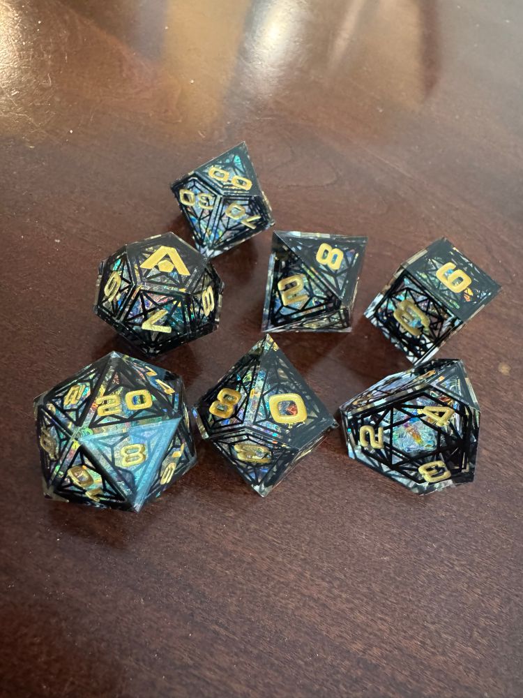 A set of seven polyhedral dice with a sort of stained-glass look: etched frames on each face and colorful glitter inside. Gorgeous!