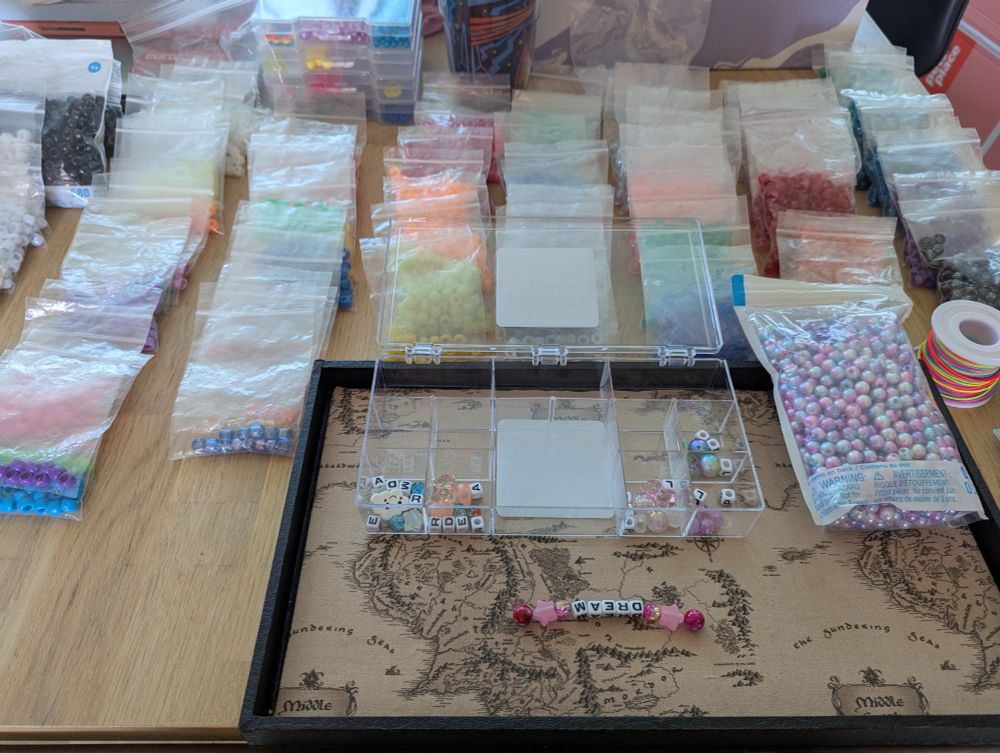 Bags of sorted beads surround a tray to line out fun creations in all colors of the rainbow