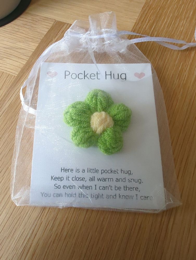 A crocheted pocket hug with card that reads, "here is a little pocket hug. Keep it close all warm and snug. So even when I can't be there, you can hold this tight and know I care."