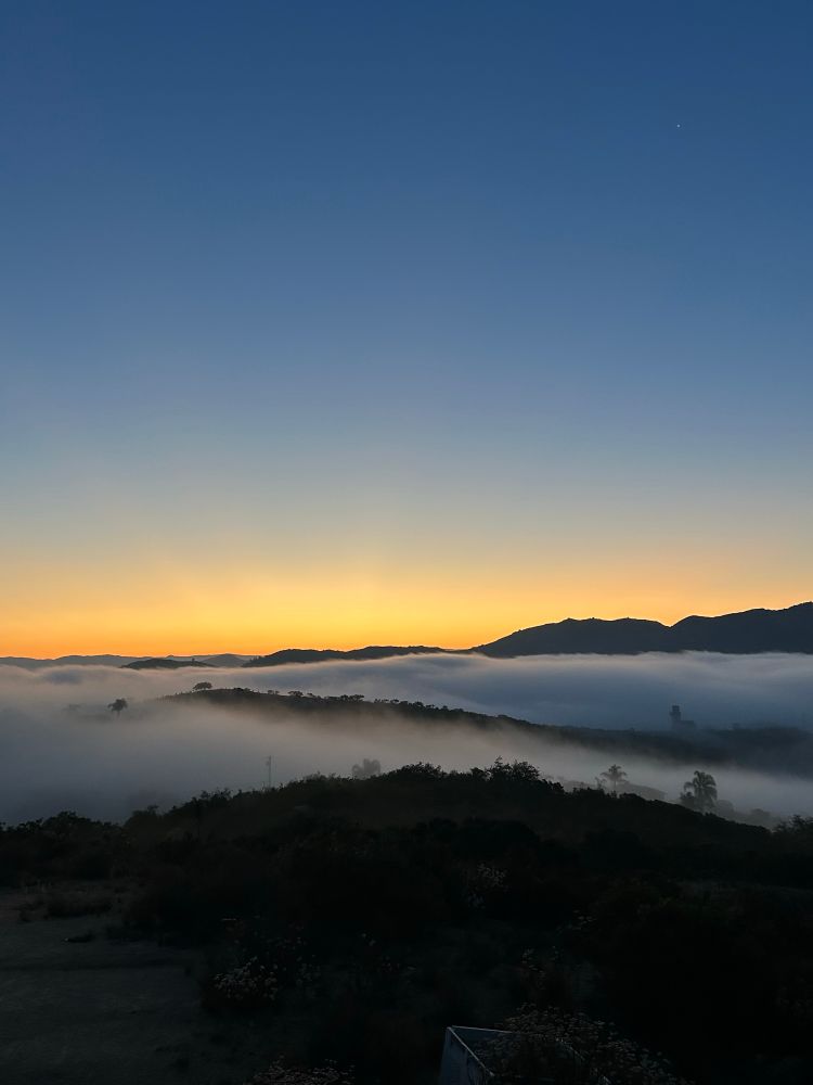 Sunrise with clouds in between hills 