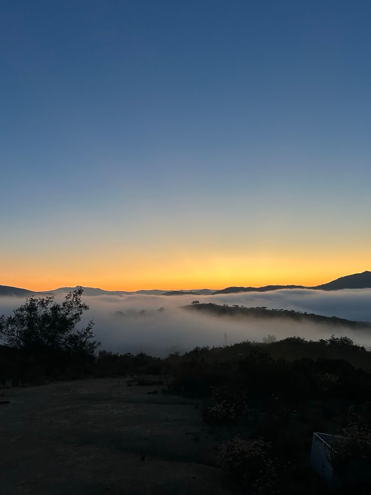 Sunrise with clouds in between hills 