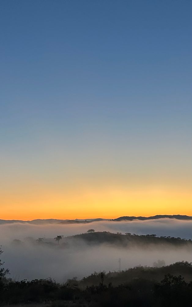 Sunrise with clouds in between hills 