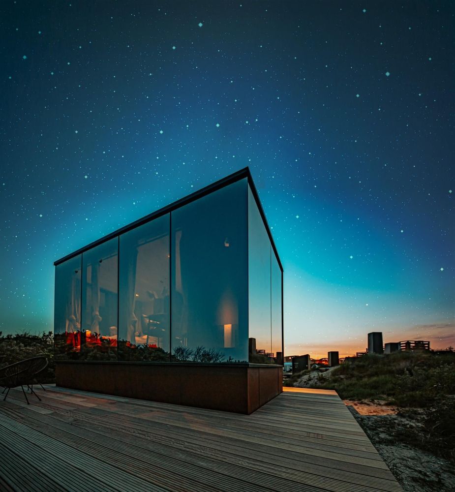 A mirrored house on a deck under the stars 