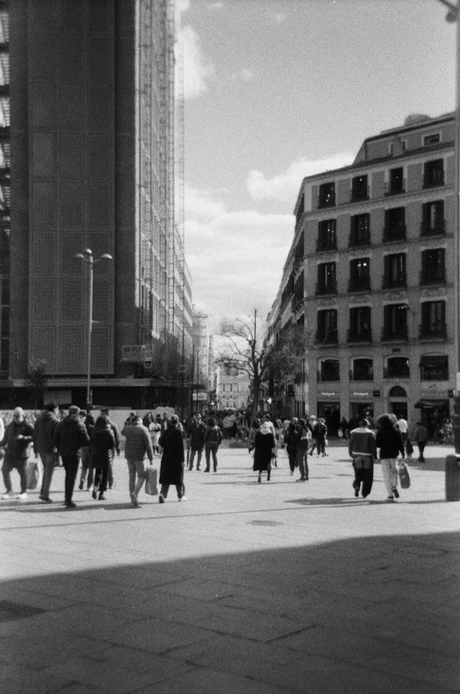 Plaça de Callao a Madrid, amb vianants passetjant. Foto vertical en blanc i negre
