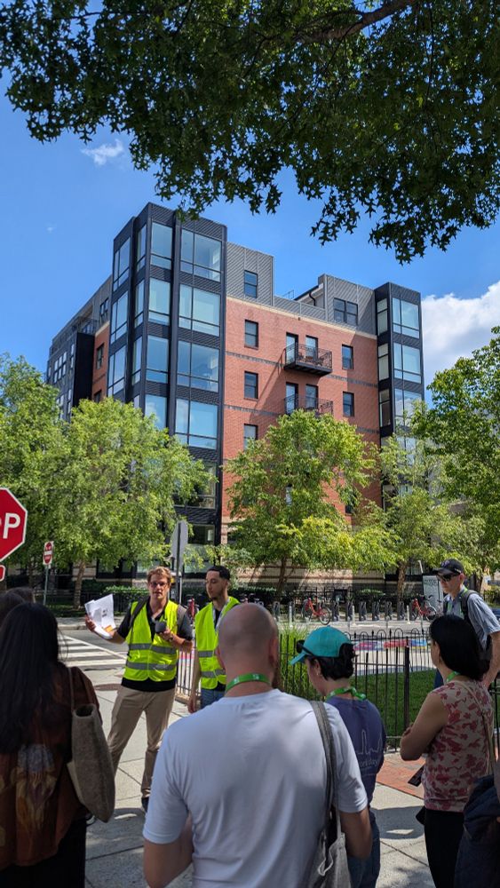 An apartment building with people talking in the foreground 