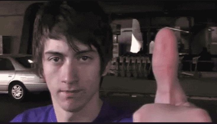 a young alex turner doing a thumbs up into the camera