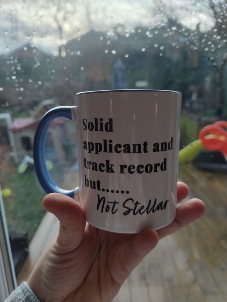 Mug that is being held up and says on the side "solid application a d track record but .... Not stellar