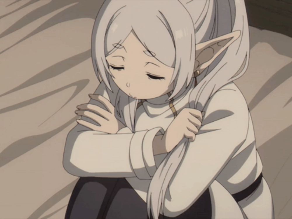 a girl with long white hair and elf ears is hugging her knees