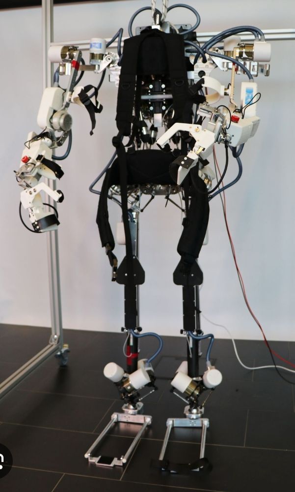 An exoskeleton robot that helps people walk. It has white arms and black legs
