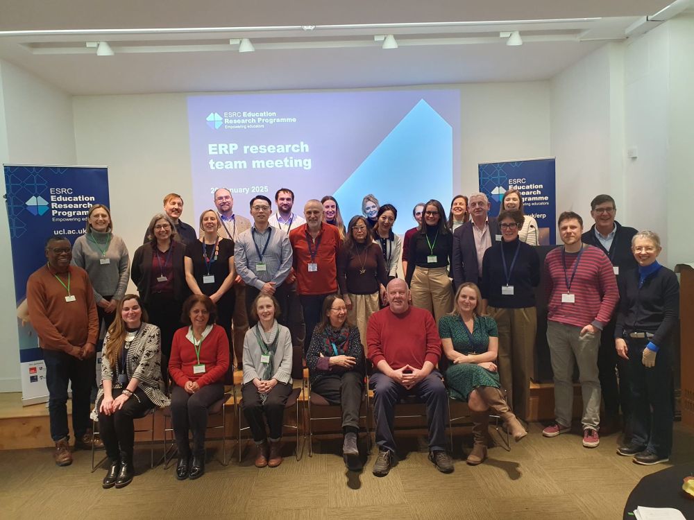 members of the nine different ERP project are grouped in three rows in front of a screen with a slide displaying 'ERP research team meeting on a blue background.  