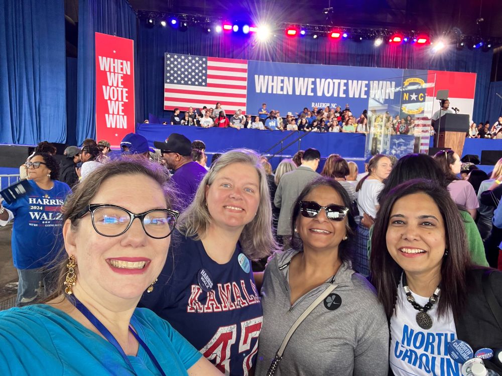 Smiling ladies at a crowded rally.