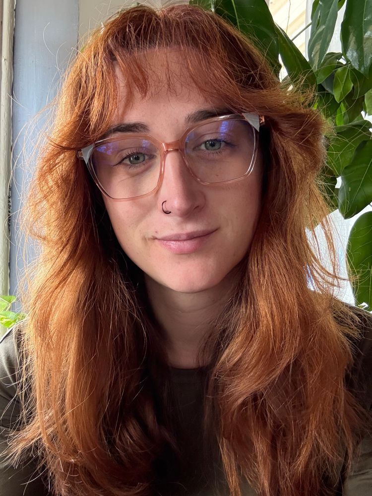 Me a pretty lady with red hair and a messy fringe wearing glasses 