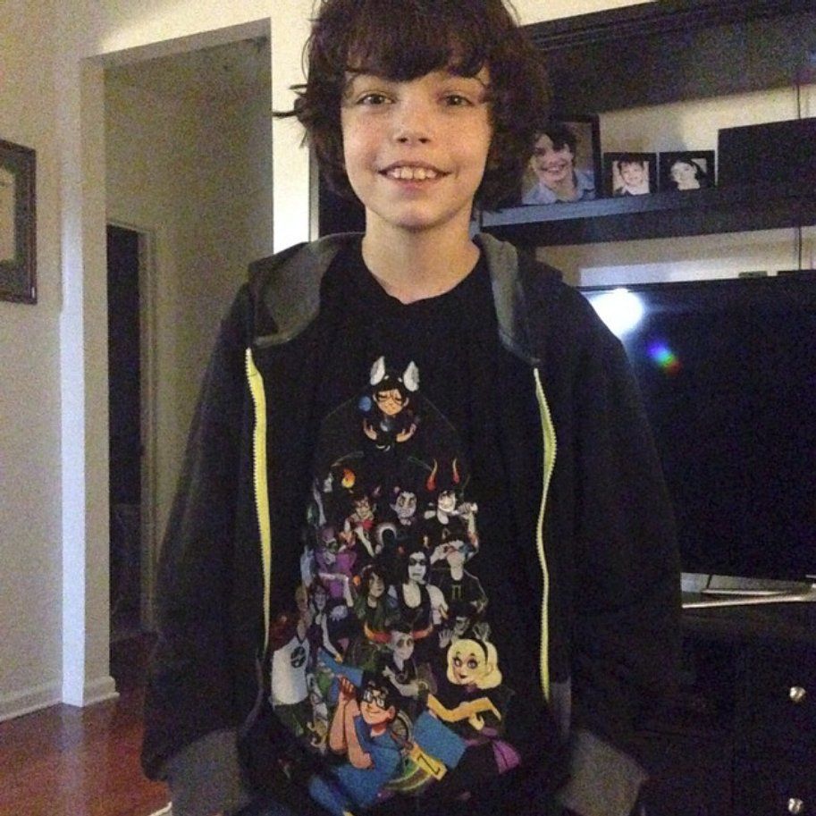 11 year old ashli in a homestuck graphic tee featuring beta kids and trolls and an oversized black and grey hoodie with a neon yellow zipper