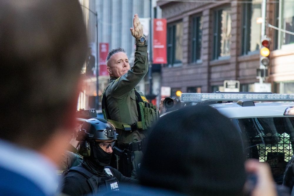 Border Patrol chief Greg Bovino gestures to a crowd of press and protesters as he gets into a truck after exiting the Federal Building on Oct. 28, 2025. Credit: Arthur Maiorella for Block Club Chicago