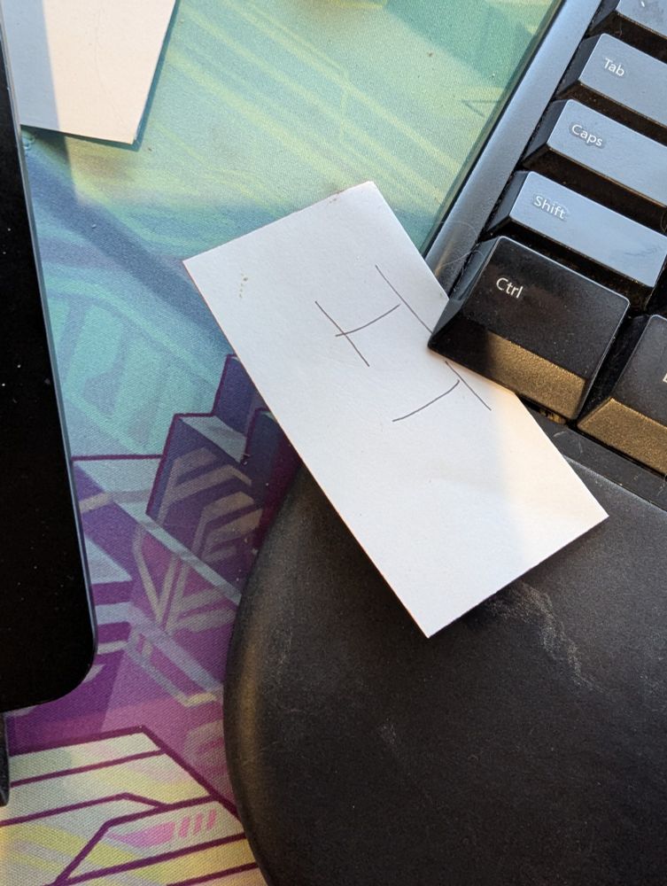 A slip of paper with the word IT, tucked under the control key on my keyboard 