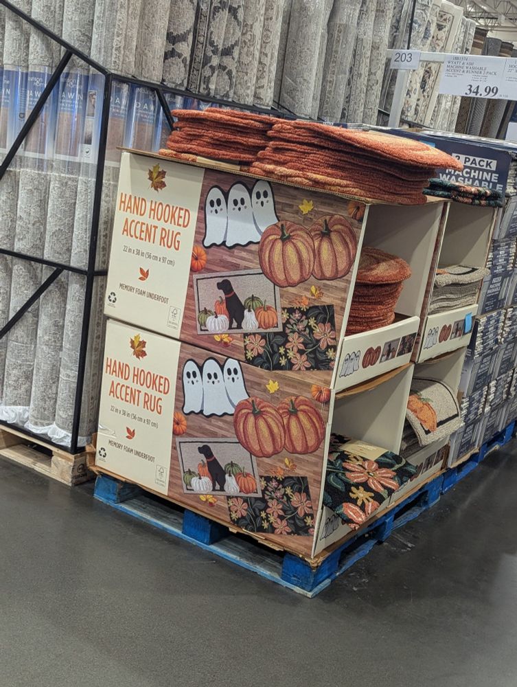 A pile of pumpkin and ghost themed rugs at costco