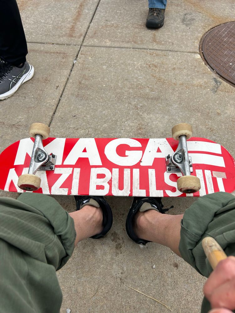 A skateboard with an anti-maga message written on it. 