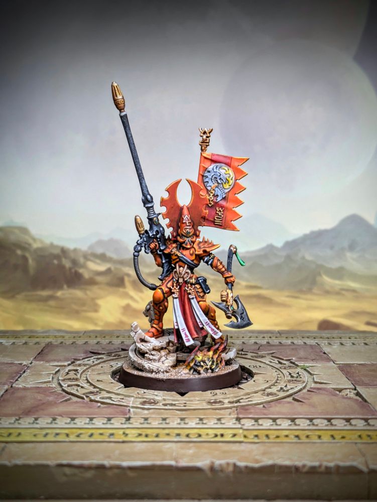 Fuegan, an Aeldari miniature in orange with a long gun and an axe. 