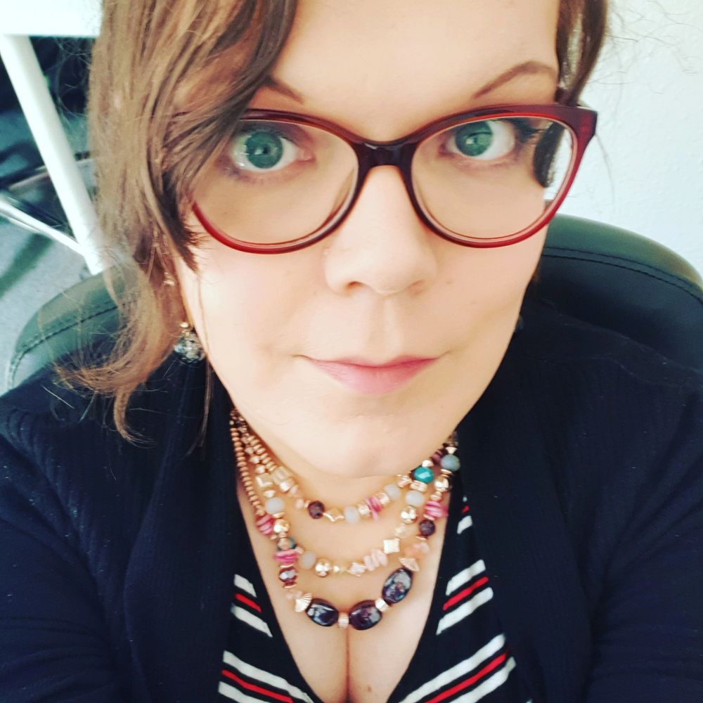 Me. A trans woman with red cat eye glasses on. 