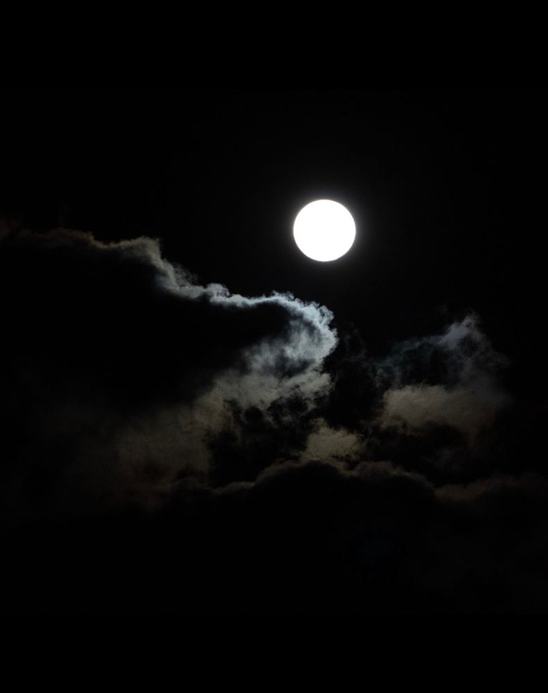 Photo: The full moon shot at night, surrounded by swirling clouds underneath