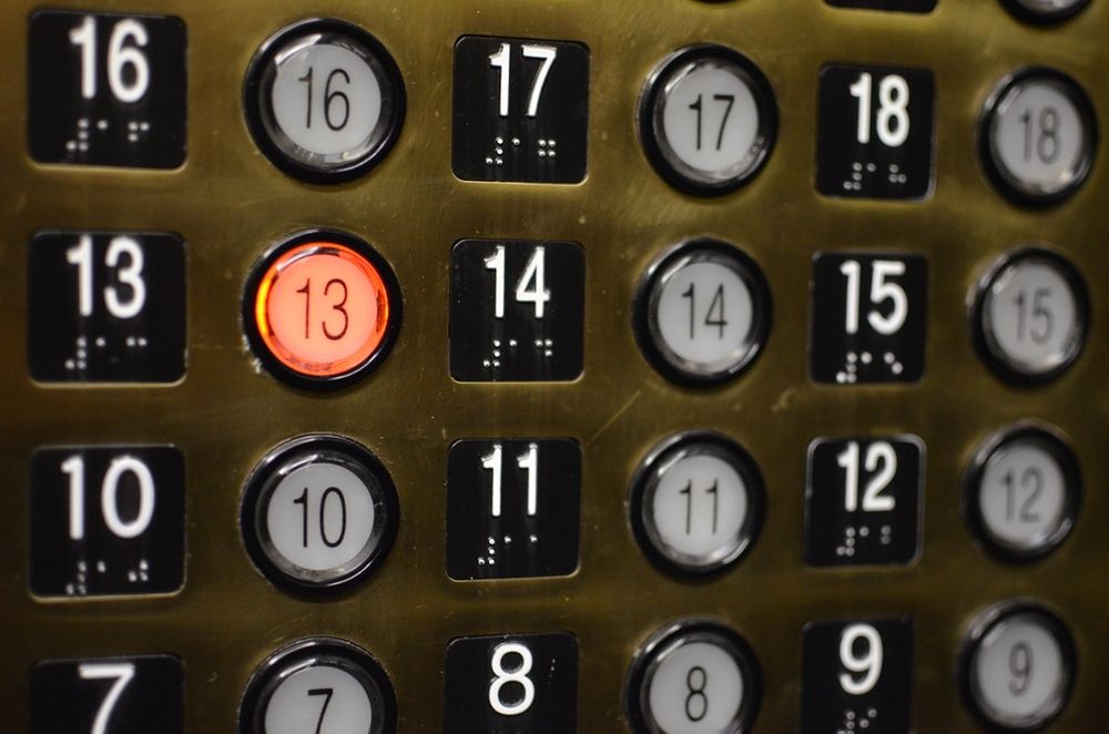 A set of elevator buttons with the one for the 13th floor lit.