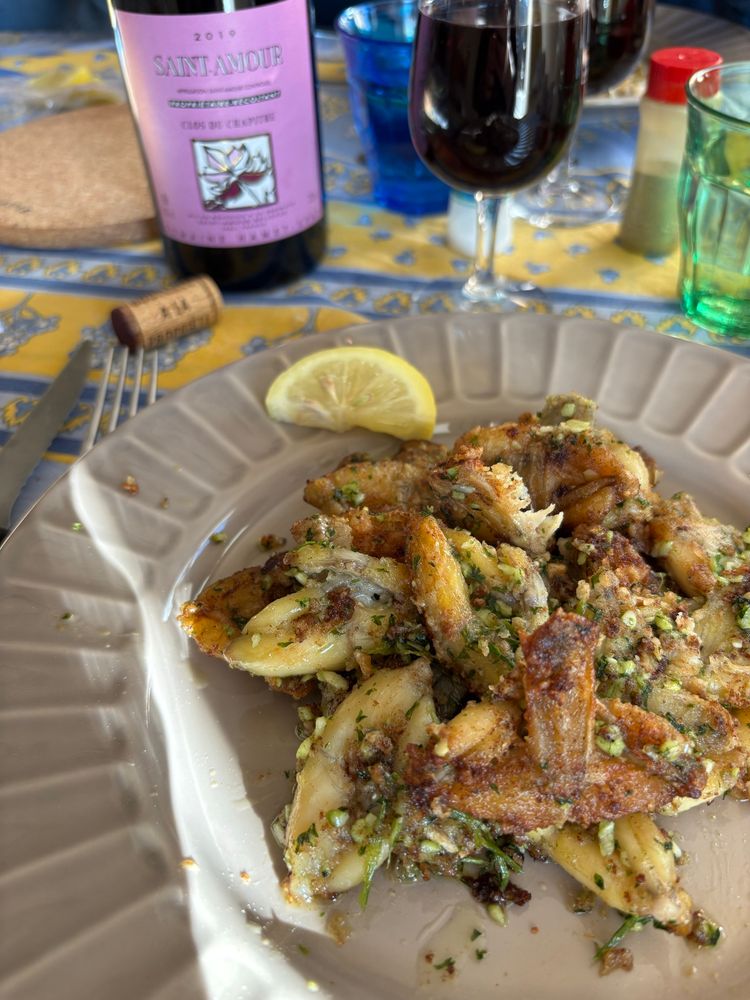 This is the picture of a French traditional platel: frogs’ legs cooked in butter, garlic, and Persley. Also on the picture, a bottle of St Amour red wine, one of the 10 beaujolais protected crus.