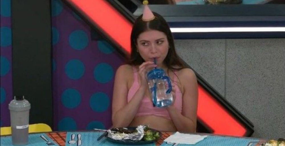 america sipping her water while giving the side eye and wearing a pink party hat