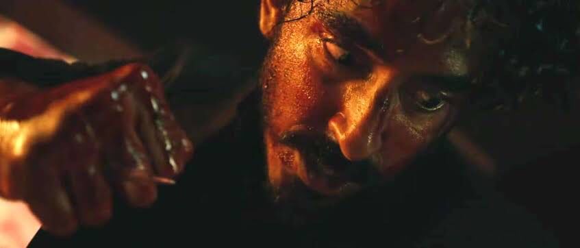 『モンキーマン』から主人公が血濡れの拳を握っているシーン