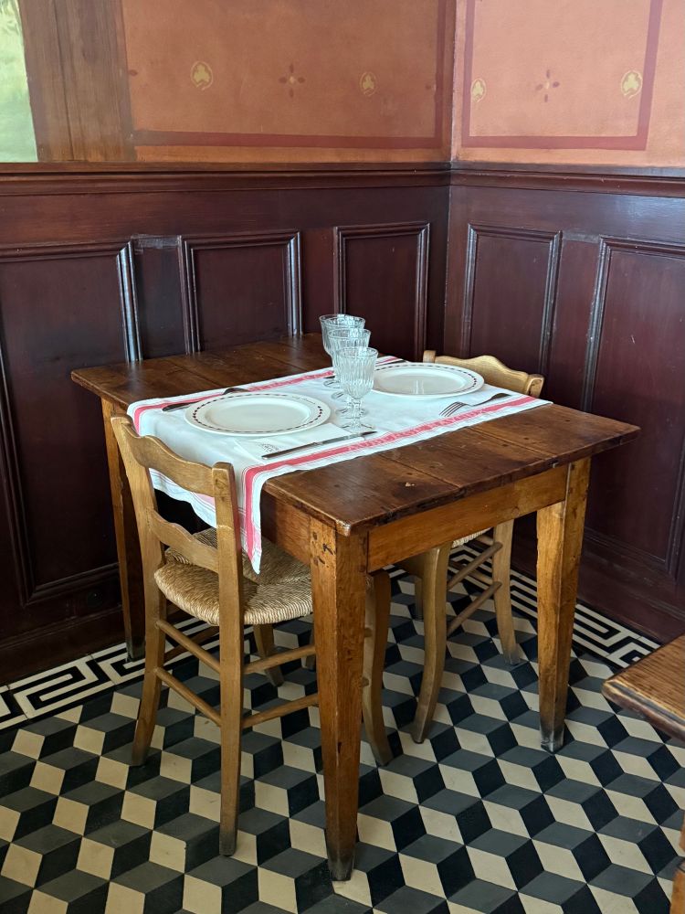 Une petite table toute simple avec le couvert pour deux personnes, la table est en bois rustique, les murs sont boisés