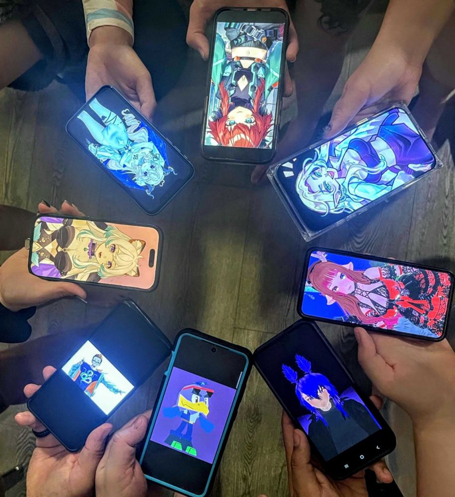 A photo of a group of people holding their phones in a circle showing off their vtuber modles