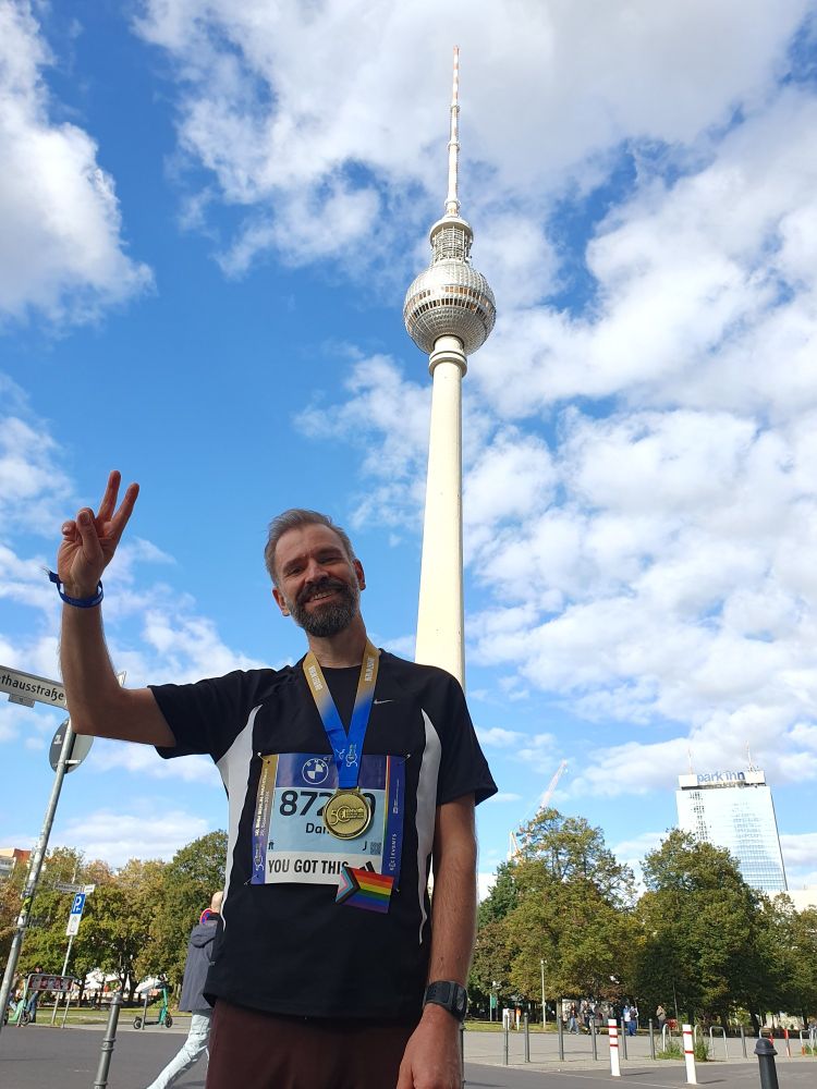Siegerpose vor dem Berliner Fernsehturm mit Medaille des 50. Berlin Marathon um den Hals.