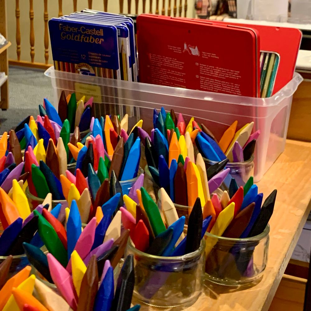 Bunte Wachsmalstifte in Gläsern. 