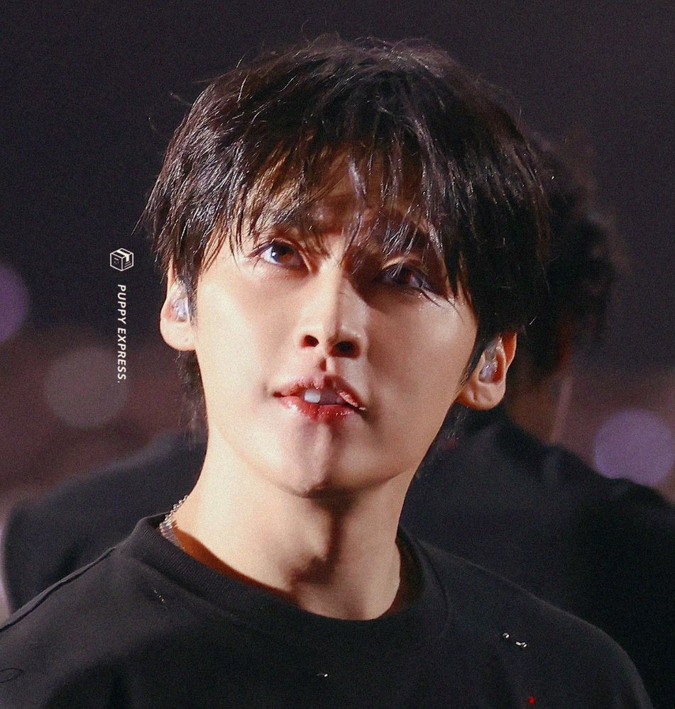 Lee Know of Stray kids again. He’s wearing black with his hair falling over his eyes. One tooth is more prominent than the others. You might see a pattern 