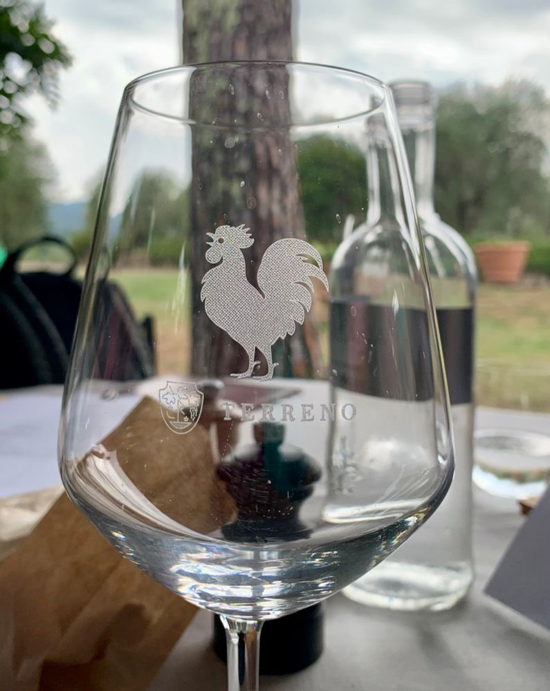 A wine glass adorned with an engraved cockerel.