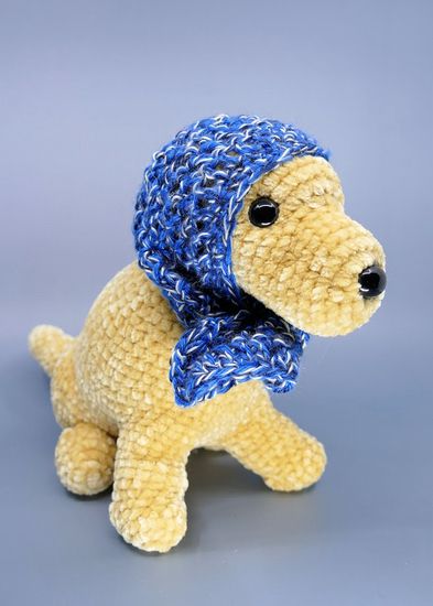 A crochet yellow dog (Flame) wearing a blue headscarf reminiscent of a Russian babushka