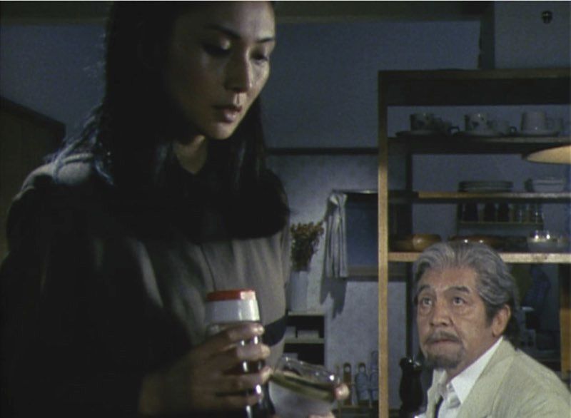 Meiko standing and looking down while Rentaro is sitting and looking up at her.