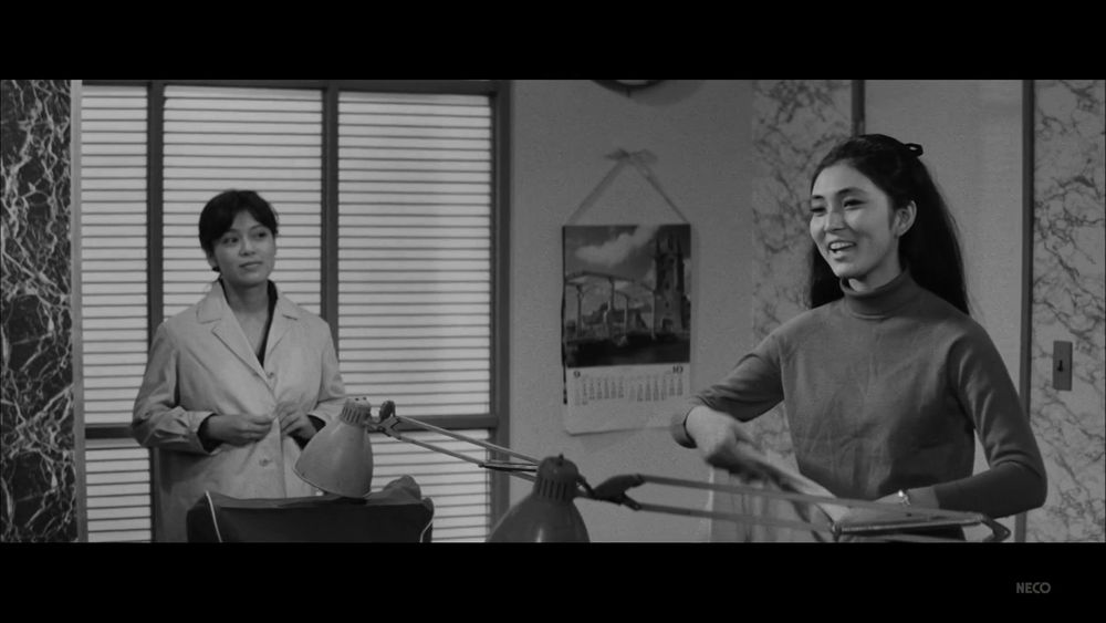 Meiko and another woman putting on their white typist(?) coats