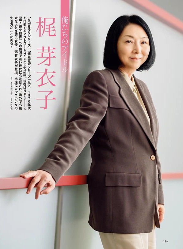 Meiko standing near a wall with one of her hands on a railing, smiling at the camera