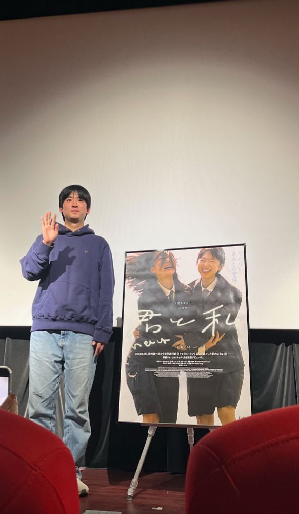 舞台上の監督と作品のポスターのボード